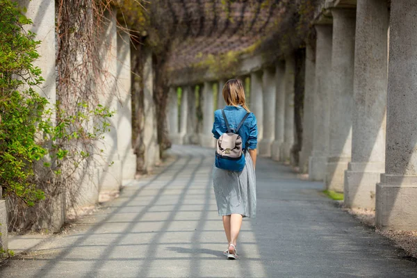 Chica caminando por el callejón con arcos y columnas — Foto de Stock