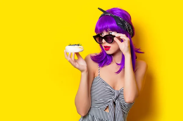 Menina com cabelo roxo segurando um bolo de creme — Fotografia de Stock