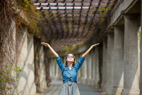 Menina andando no beco com arcos e colunas — Fotografia de Stock