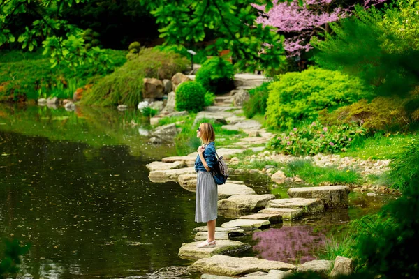 Menina elegante jovem tem um descanso perto de uma lagoa — Fotografia de Stock