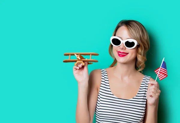 Meisje met ons vlag en houten vliegtuig — Stockfoto