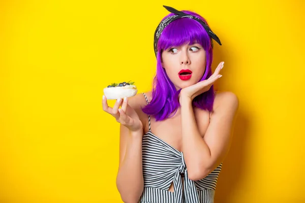 Дівчина з фіолетовим волоссям тримає крем торт — стокове фото