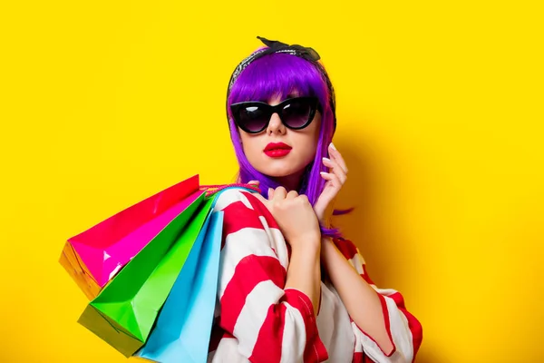 Chica con pelo morado sosteniendo bolsas de compras —  Fotos de Stock