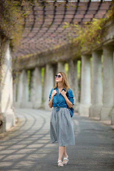 Chica caminando por el callejón con arcos y columnas —  Fotos de Stock