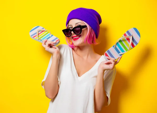 Girl in purple hat holding a flip flops — Stock Photo, Image