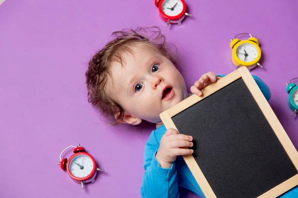 Bambino con sveglia e lavagna — Foto Stock