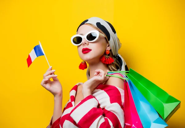 Mulher com bandeira franca e sacos de compras — Fotografia de Stock