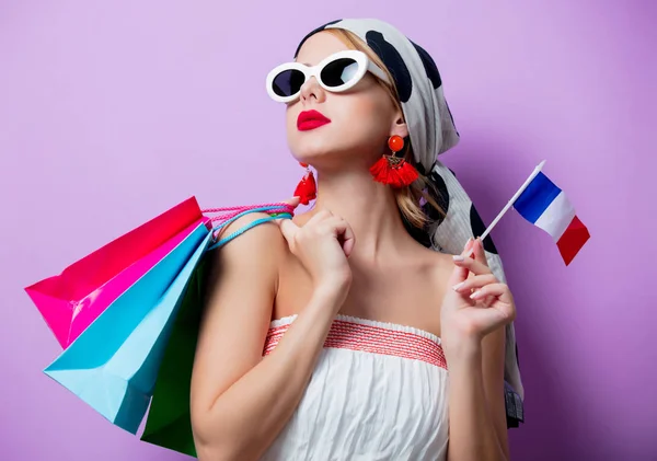 Mulher com bandeira francesa e sacos de compras — Fotografia de Stock