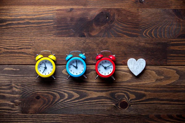 Drie Kleurrijke Wekkers Hart Vorm Houten Tafel — Stockfoto