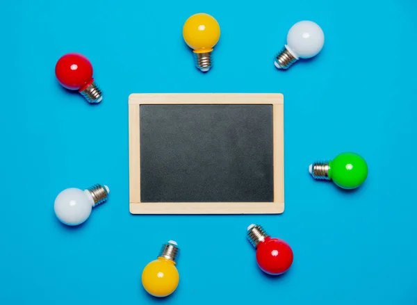 Colored Lightbulbs Blackboard Blue Background — Stock Photo, Image