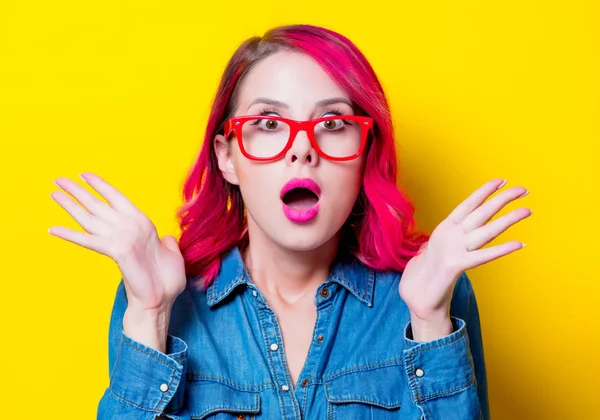 若いピンクの青いシャツと赤いメガネで髪の女の子 黄色の背景に分離された肖像画 — ストック写真