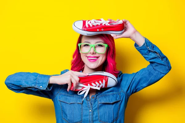 若いピンクの青いシャツと赤い願いのための半靴を保持緑メガネの髪の少女 黄色の背景に分離された肖像画 — ストック写真