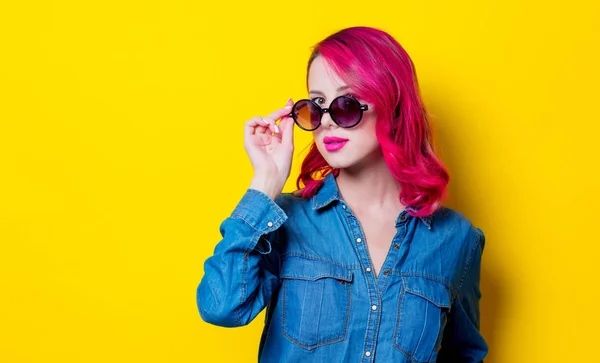 若いピンク髪少女のサングラスは 青いシャツ 黄色の背景の肖像画 — ストック写真