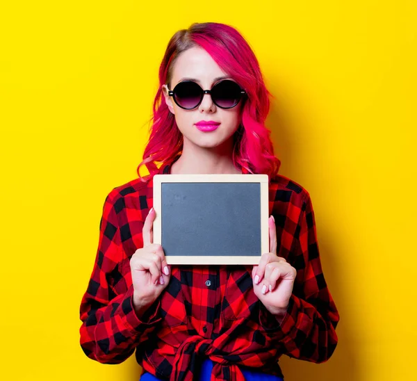年轻的粉红色的头发女孩红色格子衬衫和木板 在黄色背景上隔离的肖像 — 图库照片