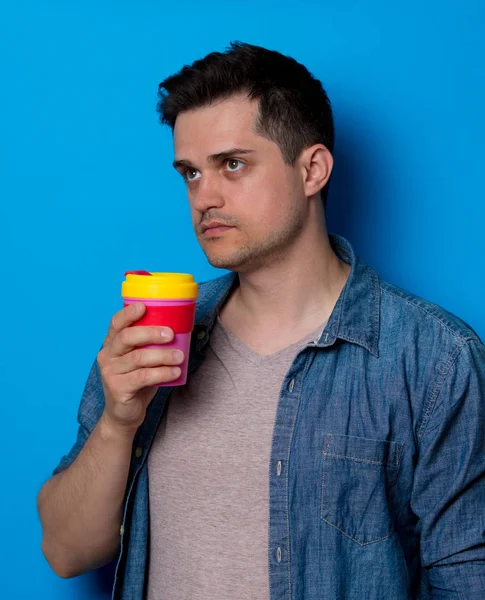 Kot gömlek renkli cup ile genç adam — Stok fotoğraf