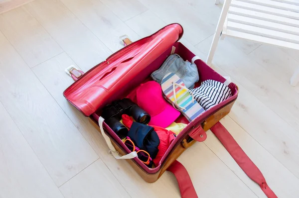 Vintage suitcase on floor with clothes inside — Stock Photo, Image