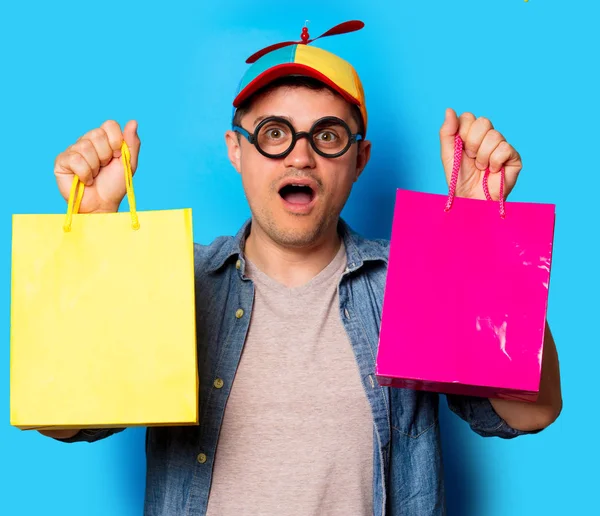 Nörd man med noob hatt hålla en shoppingkassar — Stockfoto