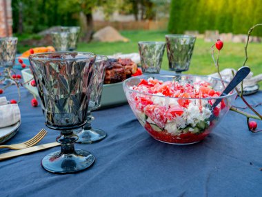 Peynirli domates salatası ve masada bardaklı diğer yiyecekler!