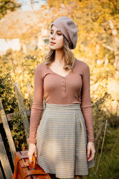 Mujer de estilo en ropa vintage con maleta al aire libre — Foto de Stock