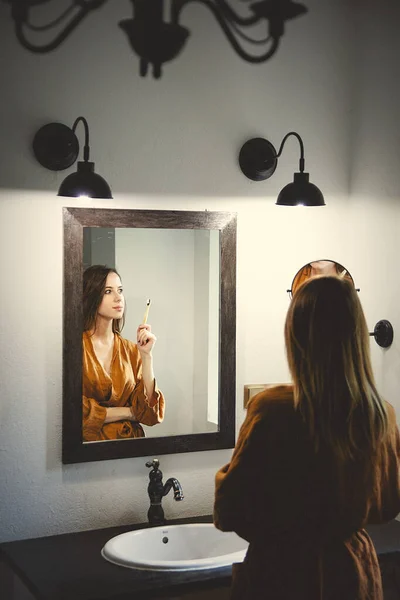 Vrouw smeert lotion in de badkamer — Stockfoto