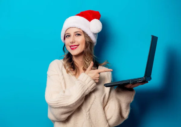 Bella donna in cappello di Natale con computer portatile su ba blu — Foto Stock