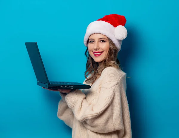 Bella donna in cappello di Natale con computer portatile su ba blu — Foto Stock