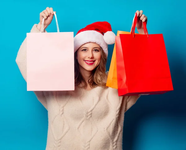 青の背景にショッピングバッグと美しい女性 — ストック写真