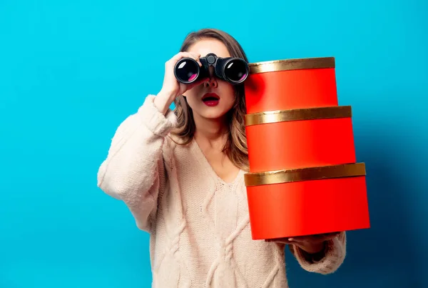 Bella donna con scatola regalo e binocolo su sfondo blu — Foto Stock