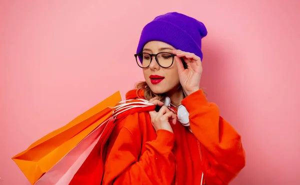 Estilo menina com capuz laranja e chapéu roxo com sacos de compras em — Fotografia de Stock