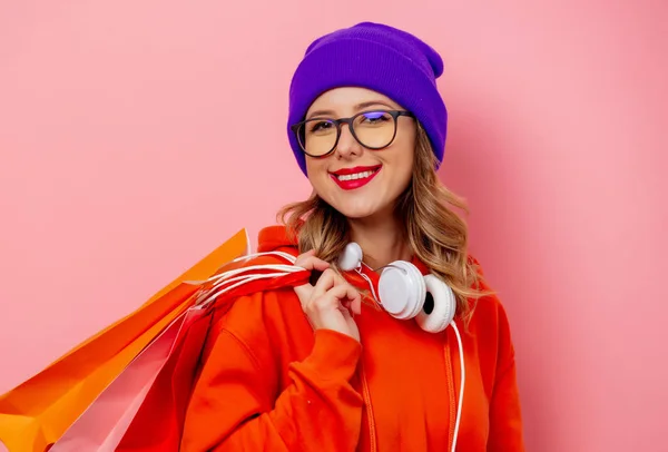 Stile ragazza con cappuccio arancione e cappello viola con borse della spesa su — Foto Stock