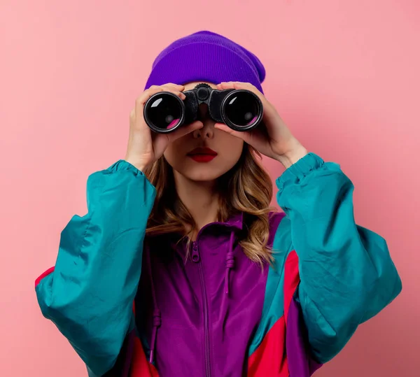 Ung kvinna i lila hatt och 90-talskläder med kikare på stift — Stockfoto