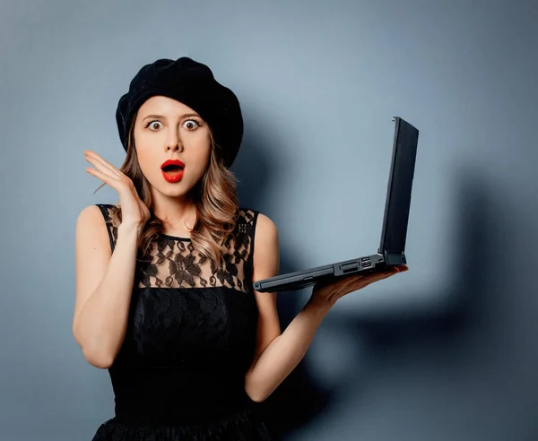 Mujer joven en vestido negro con cuaderno sobre fondo gris —  Fotos de Stock