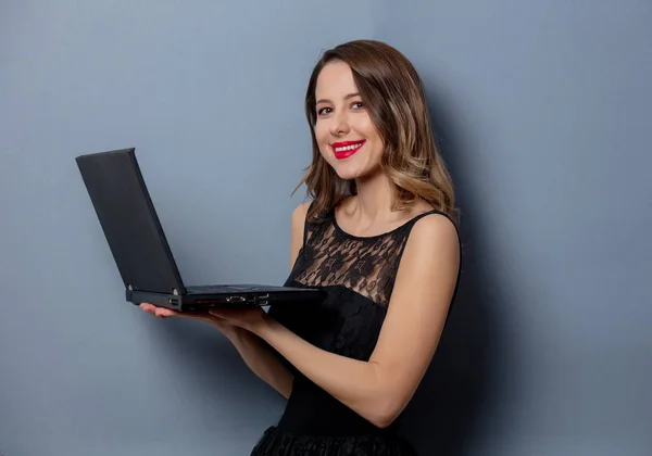 Mujer joven en vestido negro con cuaderno sobre fondo gris —  Fotos de Stock