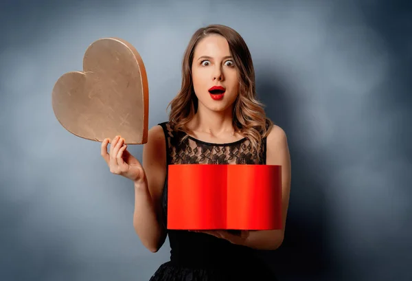 Hermosa mujer con caja de forma de corazón sobre fondo gris con bok —  Fotos de Stock