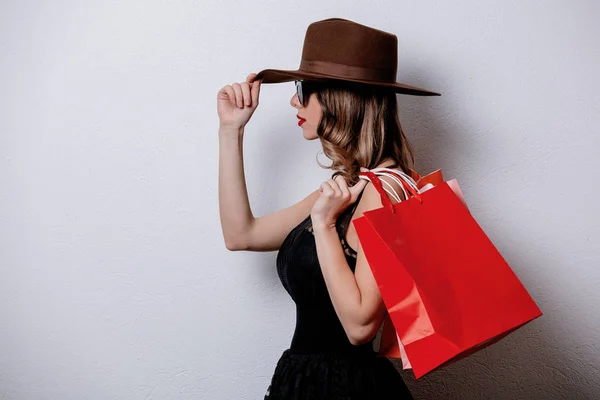 Mujer de estilo en gafas de sol con bolsas de compras sobre fondo blanco —  Fotos de Stock