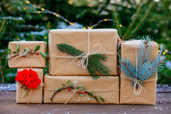 Ручної роботи різдвяні подарунки та соснове дерево на фоні — стокове фото