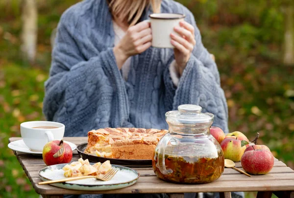 Vrouw met thee kopje en zitten in de buurt van tafel met appeltaart in g — Stockfoto