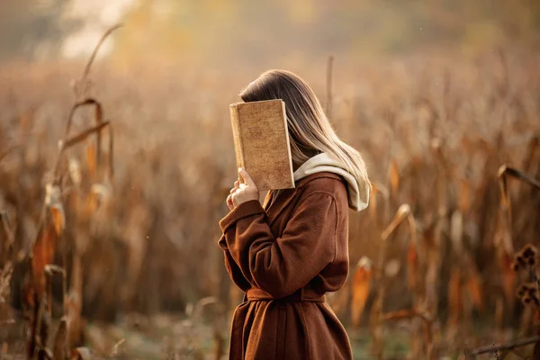 Stijl vrouw met boek op maïsveld in de herfst seizoen — Stockfoto