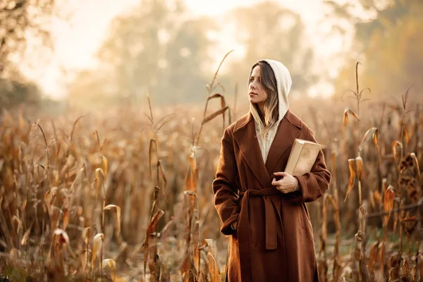 Stile donna con libro sul campo di mais nella stagione autunnale — Foto Stock