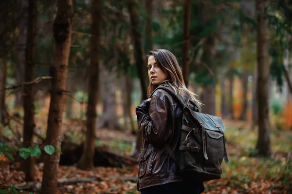 Девушка с рюкзаком в осеннем лесу — стоковое фото