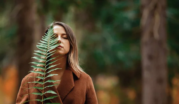 Frau mit Farnzweig im herbstlichen Wald — Stockfoto