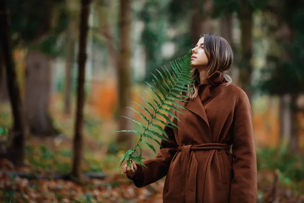 Femme de style avec branche de fougère dans une forêt d'automne — Photo