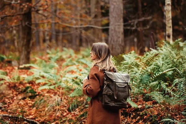 Lány hátizsákkal az őszi erdőben — Stock Fotó