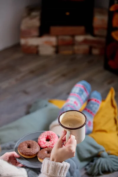 Fille avec une tasse de café et beignets près de la cheminée à la maison — Photo