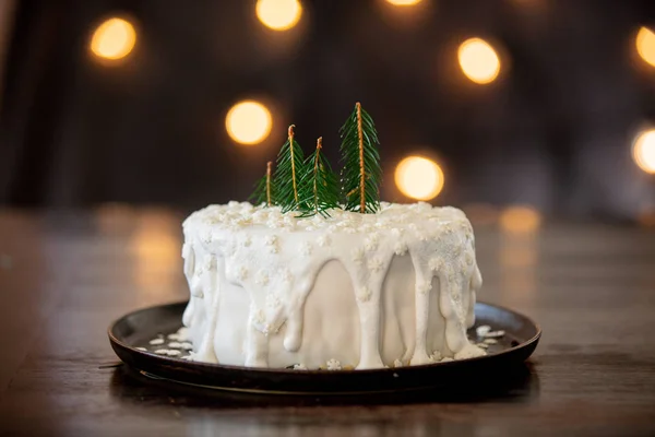 Torta di Natale con crema sul tavolo con luci di fata — Foto Stock