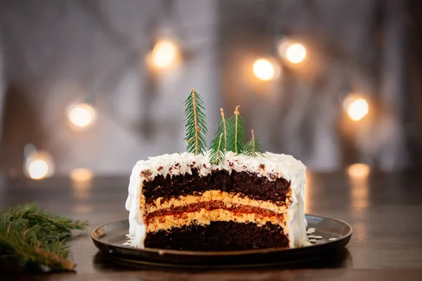 Christmas cake with cream on table with fairy lights — 스톡 사진