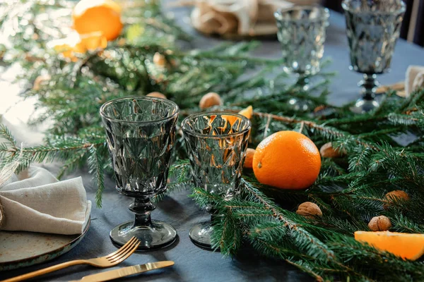 Tazze di vetro sul tavolo accanto a un piatto e abete a Natale — Foto Stock