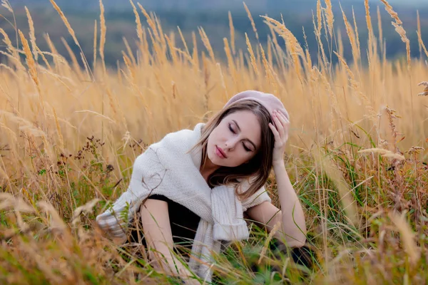 Style girl in sweater sits in yellow grass at countryside with m — Stock Photo, Image