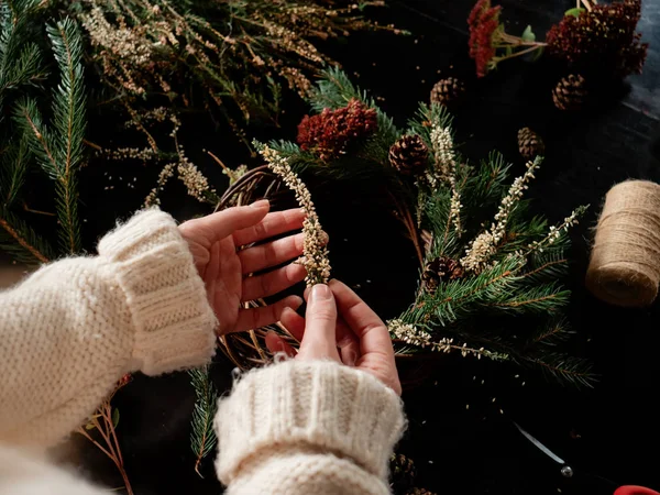 Woman in white sweater making a Christmas wreath — Stock Photo, Image