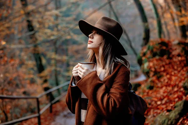 秋の公園でコーヒーを飲みながら若い女性 — ストック写真